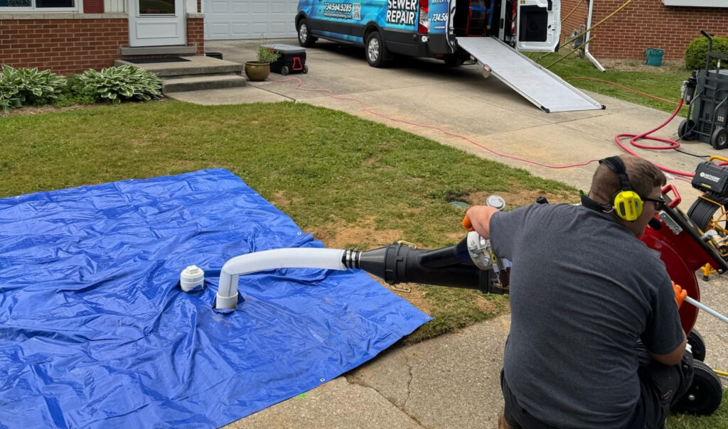 Velocity Master Plumbing & Trenchless Solutions technician performing residential trenchless sewer service in Saline, MI